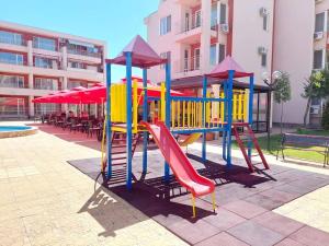 a playground with a colorful slide in a courtyard at Nessebar Fort Club apartment 363 in Sunny Beach