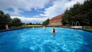 two people swimming in a large swimming pool at Farma Jamienko in Jamienko