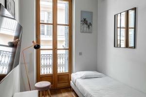 une petite pièce avec un lit et une fenêtre dans l'établissement Résidence du Vieux-Port Cannes, à Cannes