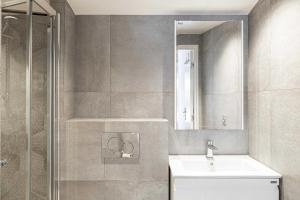 une salle de bains avec douche, lavabo et miroir dans l'établissement Résidence du Vieux-Port Cannes, à Cannes