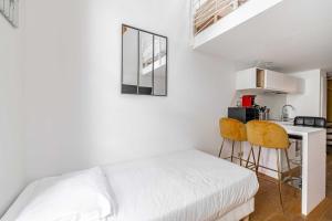 - une chambre avec un lit, une table et deux chaises dans l'établissement Résidence du Vieux-Port Cannes, à Cannes