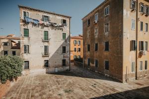 une rue vide dans une vieille ville avec des bâtiments dans l'établissement Accogliente Monolocale Veneziano2 Aria Condizionata, vicino a campus e stazione, à Venise