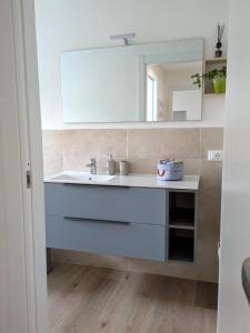 Un baño con un lavabo blanco y un espejo. en Villa Sara, en Lucca