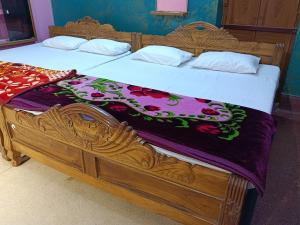 a bedroom with a wooden bed with a wooden frame at Virat Palace in Deoghar