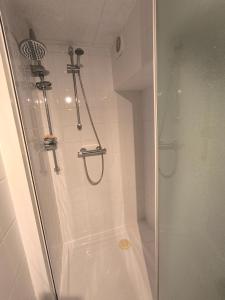 a bathroom with a shower with a glass door at Welcome home F2 in Stains