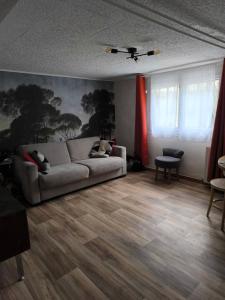 a living room with a couch and wooden floors at Welcome home F2 in Stains