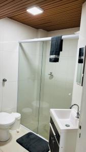 a bathroom with a shower and a toilet and a sink at Apartamento Mar grosso 100 metros do MAR in Laguna