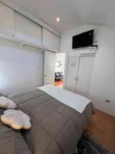 a bedroom with a large bed and a flat screen tv at Departamentos Egaña in Puerto Montt