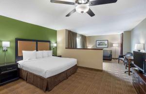 a hotel room with a bed and a ceiling fan at Extended Stay America Suites - Grand Rapids - Kentwood in Grand Rapids