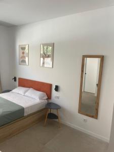 a bedroom with a bed and a mirror and a stool at Galdós Flats by Vivo GC in Valencia