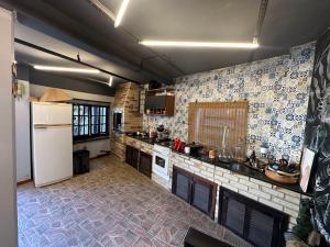 a kitchen with a white refrigerator and a tile floor at Araújo Residence - Lar Doce Lar in Joinville