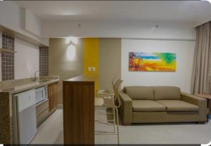 a living room with a couch and a kitchen at Olímpia ao lado do Thermas in Olímpia +4 photos