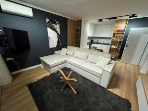 a living room with a white couch and a kitchen at Seaview Smart Home 2 in Varna City