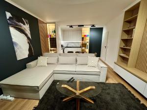 a living room with a white couch and a table at Seaview Smart Home 2 in Varna City