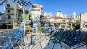 un balcon avec des chaises et des tables dans une ville dans l'établissement Hospedaria da Mama 4 quartos Shopping e Metrô Santa Cruz, à São Paulo