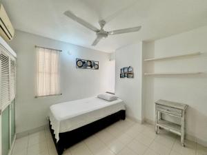 a bedroom with a bed and a ceiling fan at Apartamento a 3 cuadras del mar en Santa Marta in Rodadero