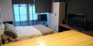 a bedroom with a bed and a flat screen tv at Monoambiente Nueva Córdoba UNC in Cordoba