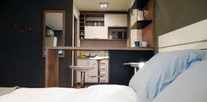 a bedroom with a bed and a kitchen with a counter at Monoambiente Nueva Córdoba UNC in Cordoba