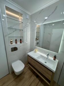 a white bathroom with a toilet and a sink at Seaview Smart Home 2 in Varna City +11 photos