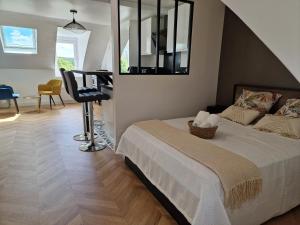 a bedroom with a bed and a table and a chair at Appartement cosy in Étampes