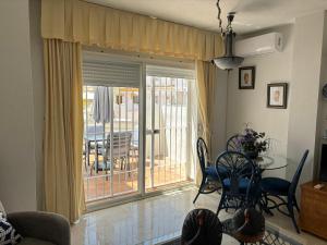 a living room with a table and a glass door with a patio at apartamento El Farillo Calahonda in Calahonda