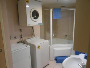 a small bathroom with a shower and a toilet at City Plaza in Canberra