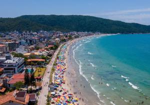 Una vista aérea de una playa con gente y sombrillas. en Bomar Residence, en Bombinhas
