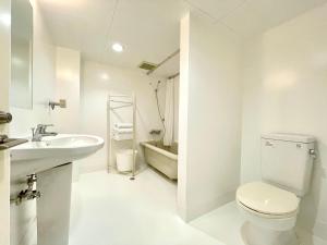 a white bathroom with a toilet and a sink at 彩光堂Village KAME101&202 in Tokyo