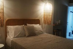 a bedroom with a bed with white pillows at Mairyren in Ano Syros