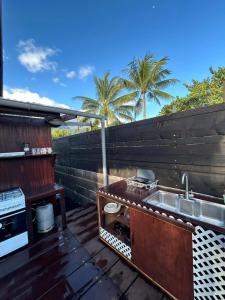 a kitchen with a sink on a deck with palm trees at Vaianae Sands in Haapiti +10 photos