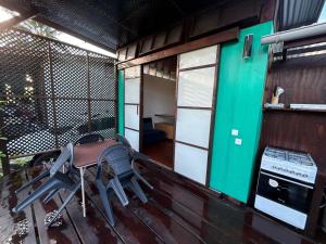 a porch of a house with a table and chairs at Vaianae Sands in Haapiti