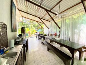 eine Küche mit einem Tisch und Bänken in einem Zimmer in der Unterkunft Ballena Dorada Lodge in Uvita
