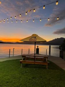 a picnic table with an umbrella in front of the water at Lucinda Cove Resort in Lucinda