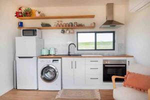 a kitchen with a washer and dryer in a tiny house at Amaroo in Timboon