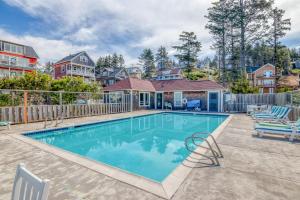 ein Swimmingpool mit zwei Stühlen und einem Haus in der Unterkunft Coral Crest in Lincoln City