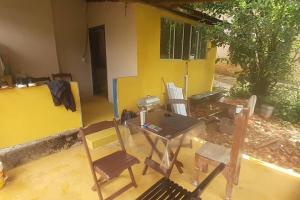 a room with a table and chairs in front of a house at Casinha Chamone in PatrimÃ´nio da Penha