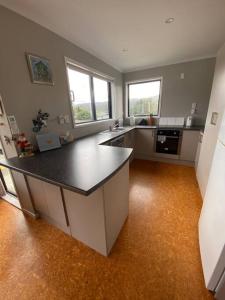 a large kitchen with a large island in the middle at The Beach Hut in Mangonui +19 photos