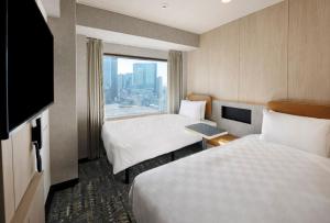 a hotel room with two beds and a large window at Shinjuku Prince Hotel in Tokyo