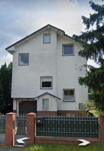 a white house with a fence in front of it at Adam room 7 in Wrocław