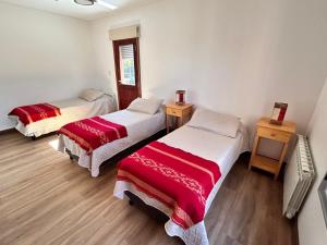 a room with three beds in a room at Al Puente y Palo - Casa de Piedra in San Lorenzo +33 photos