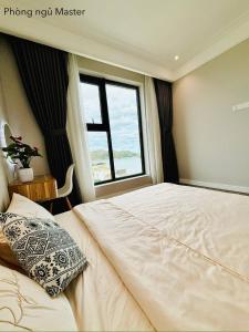 una camera da letto con un letto grande con una finestra di ALTARA Residences Quy Nhơn-Sam n' Sea Apartment-Căn hộ homestay view biển có hồ bơi a Quy Nhon