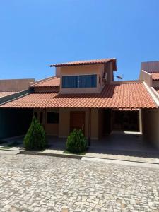 ein Haus mit rotem Dach und einer Ziegelsteinfahrt in der Unterkunft Casa na praia do coqueiro in Luis Correia