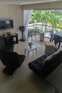 a living room with couches and a television and a table at Encantador Apartamento Ciudadela in Santa Fe de Antioquia