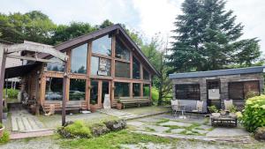 鸣泽市パディーフィールド的一座大型木制房子,有很多窗户