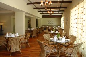 un restaurante con mesas y sillas y una lámpara de araña en Hassan Ashok, en Hassan