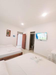 a room with two beds and a painting on the wall at Hotel El Tesoro in Puerto Boyacá