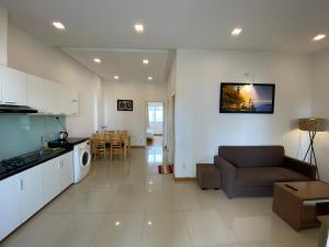 a living room and kitchen with a couch and a table at Pearl Service Apartment in Ho Chi Minh City
