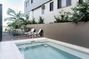 a swimming pool in front of a building at The Hamptons Lake House - Noosa Heads Luxury House in Noosa Heads