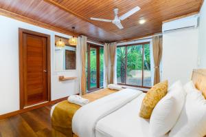 a bedroom with a white bed and a large window at Ostrov Beach in Ukulhas