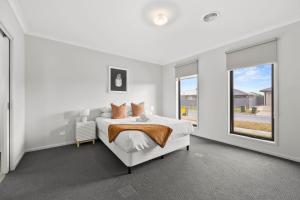 a white bedroom with a bed and a window at The Alfredton - Spacious Ballarat Stay for Families in Alfredton